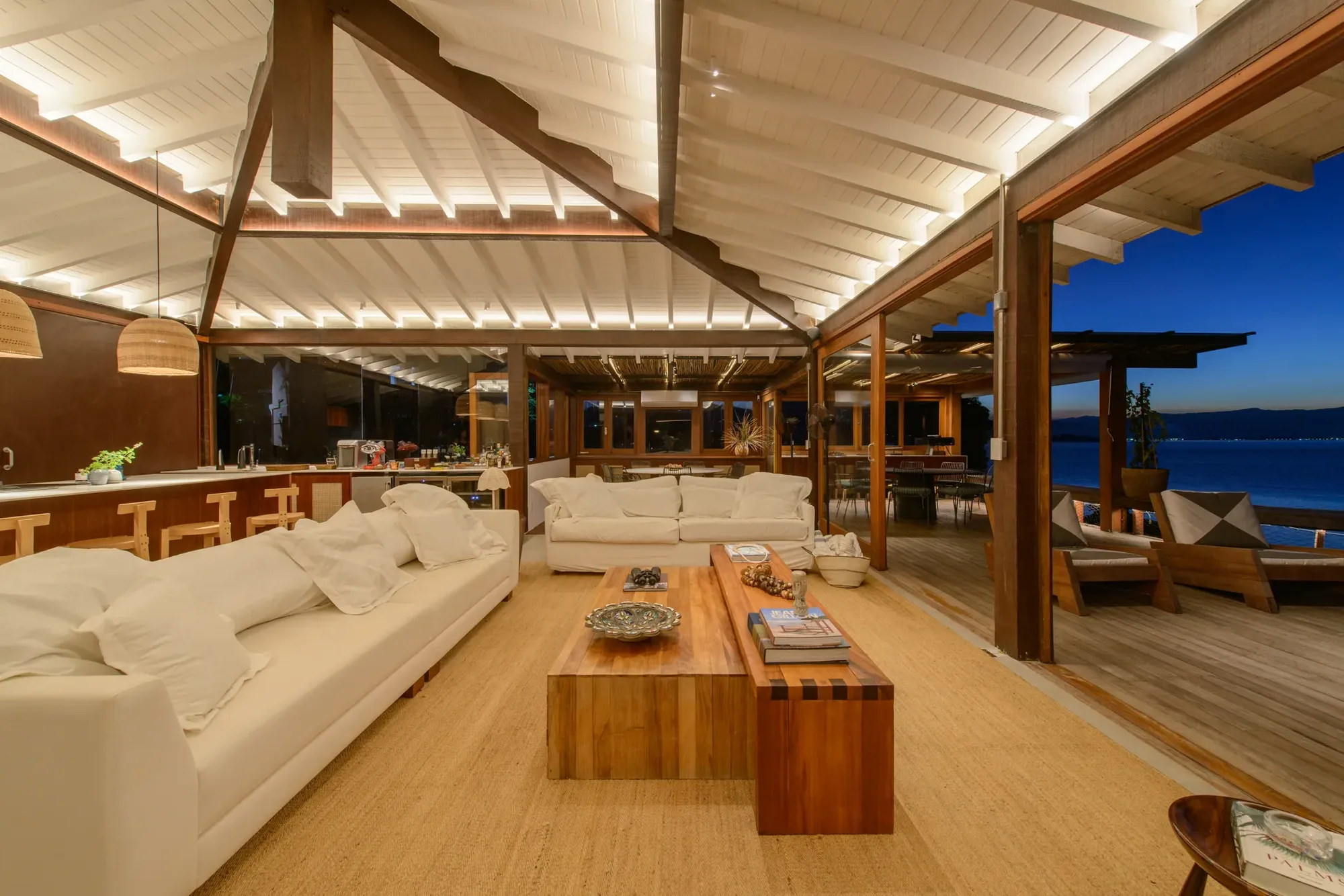 Sala da Residência Ilhabela ao anoitecer, com a luz em camadas